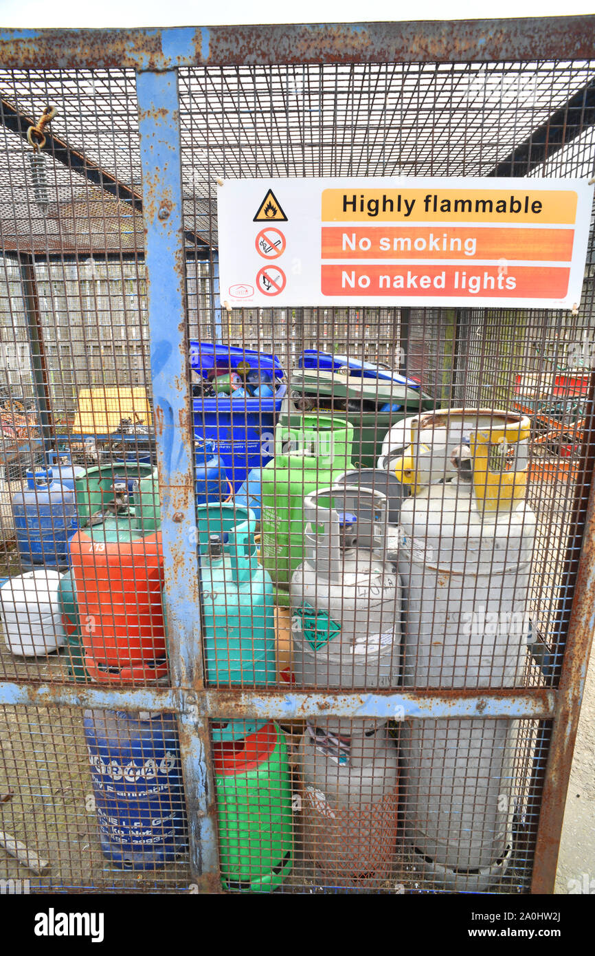 Les bouteilles de gaz dans la cage de sécurité en attente de recyclage en recyclage de déchets ménagers conseil Royaume-Uni centre Banque D'Images