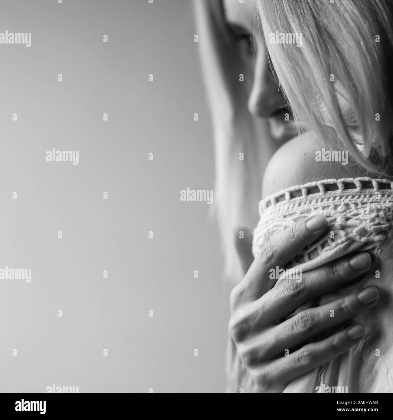 Soft portrait d'une jeune fille avec la main sur l'épaule, vue latérale de profil, photo en noir et blanc. Banque D'Images