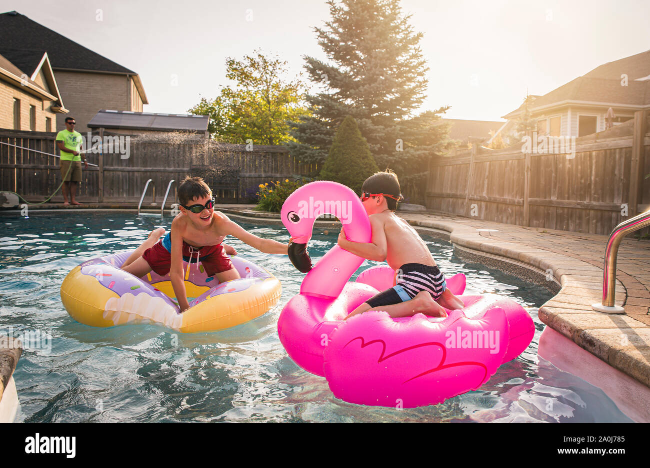 Deux garçons jouant dans une piscine sur piscine gonflable jouets. Banque D'Images
