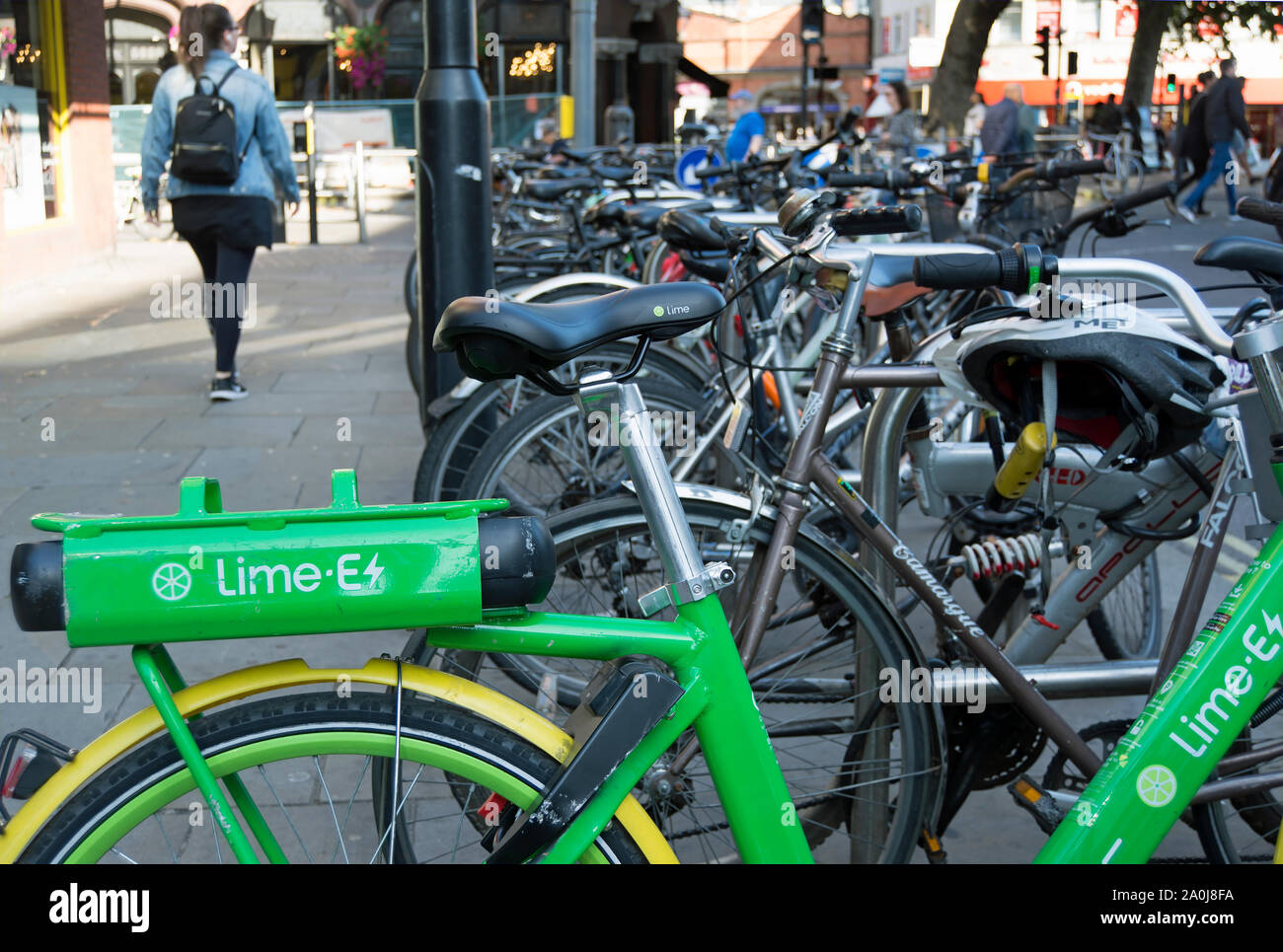 Un dockless lime électrique vélo garé entre vélos classiques à Hammersmith, Londres, Angleterre Banque D'Images