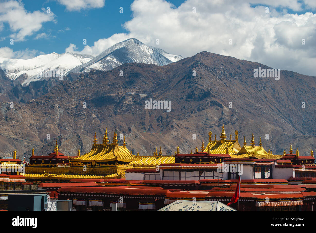 Les toits d'or du Temple de Jokhang position contre des montagnes enneigées à Lhassa, au Tibet. Le temple est le temple le plus saint dans tous les of Tibetan Budd Banque D'Images