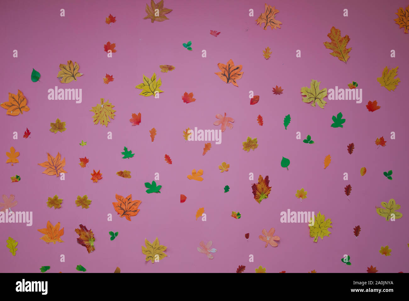 Faites de feuilles de papier sur un fond rose. Les feuilles d'automne papier rouge, orange, jaune la chute des feuilles. Banque D'Images