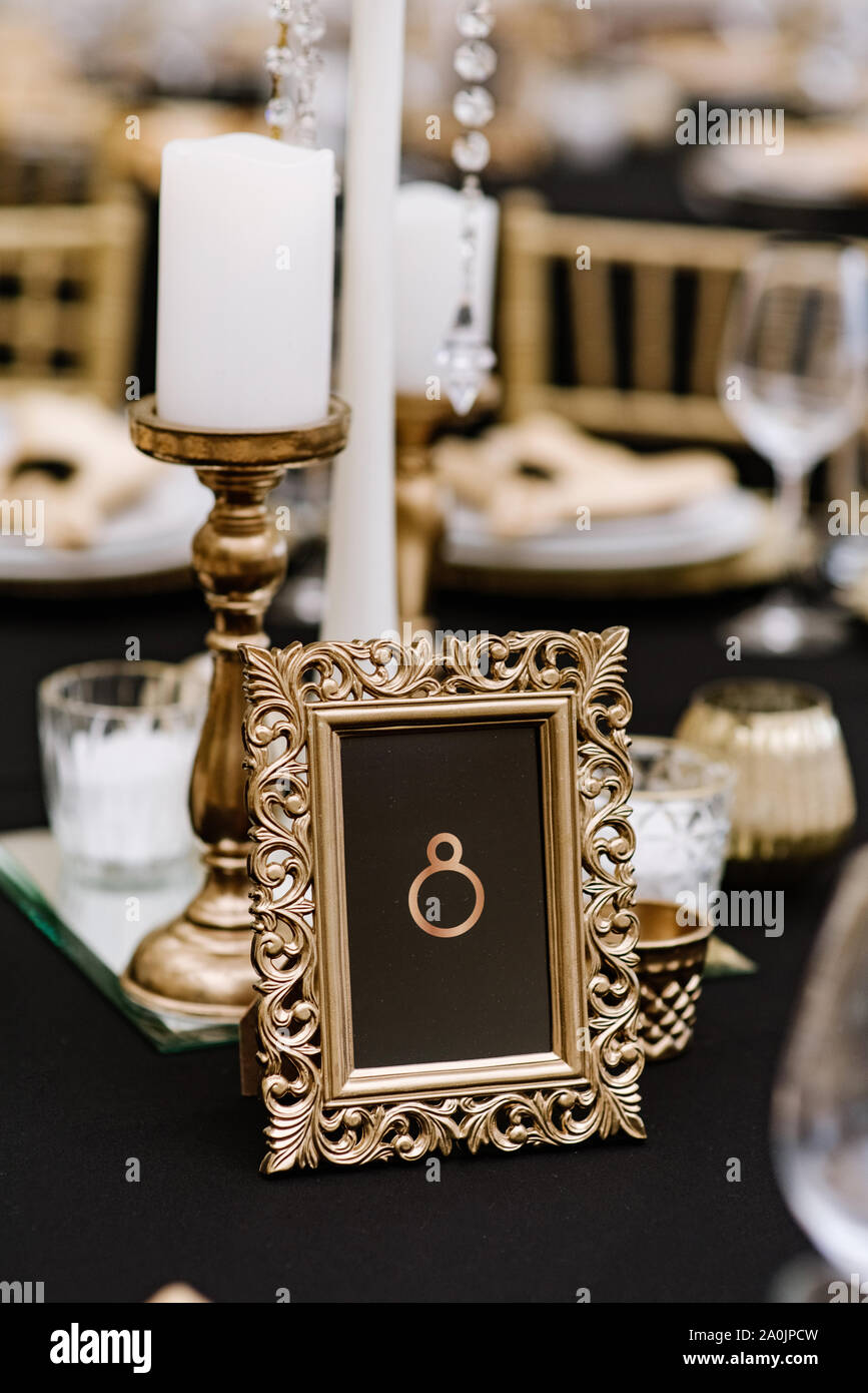 Un cadre doré rectangulaire avec un numéro de table se dresse sur une table  de mariage élégant pour les clients Photo Stock - Alamy