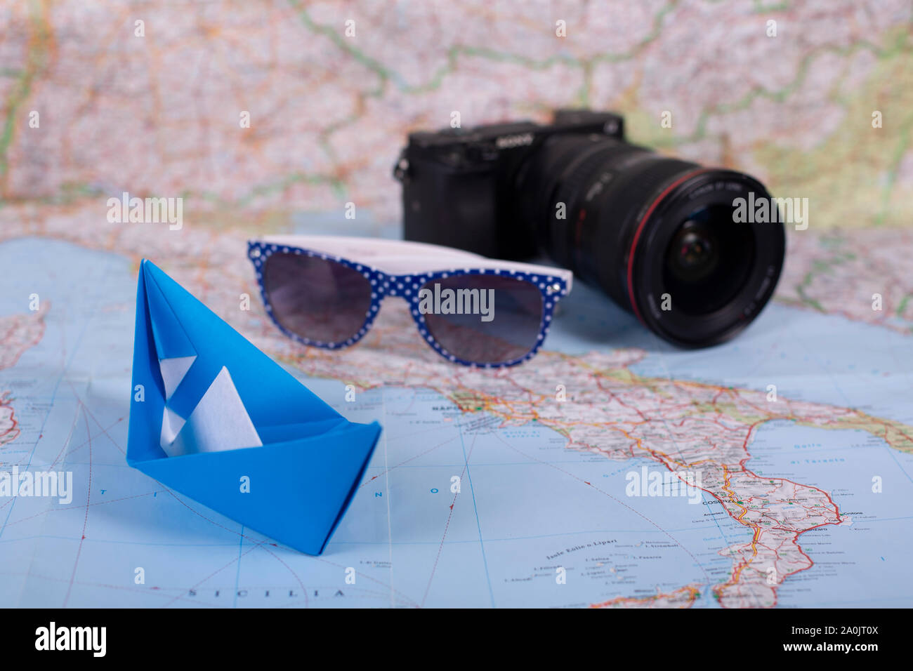 Locations de vacances voyage origami papier fait main concept papercraft  navire avec l'appareil photo et des lunettes de soleil sur la carte proche  de l'Italie close up shot studion Photo Stock -