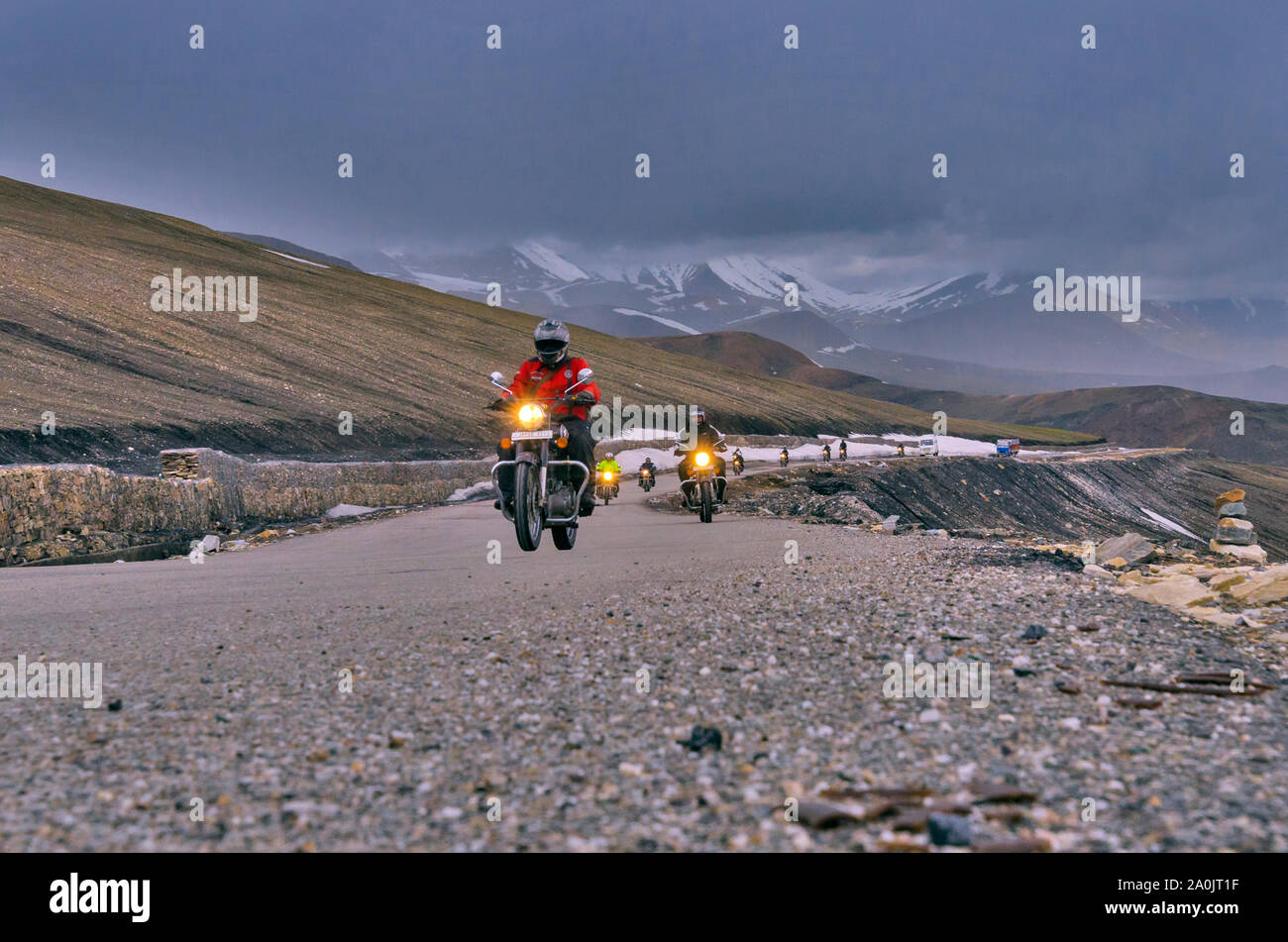 Les motards traversant le col dans le temps nuageux. Banque D'Images