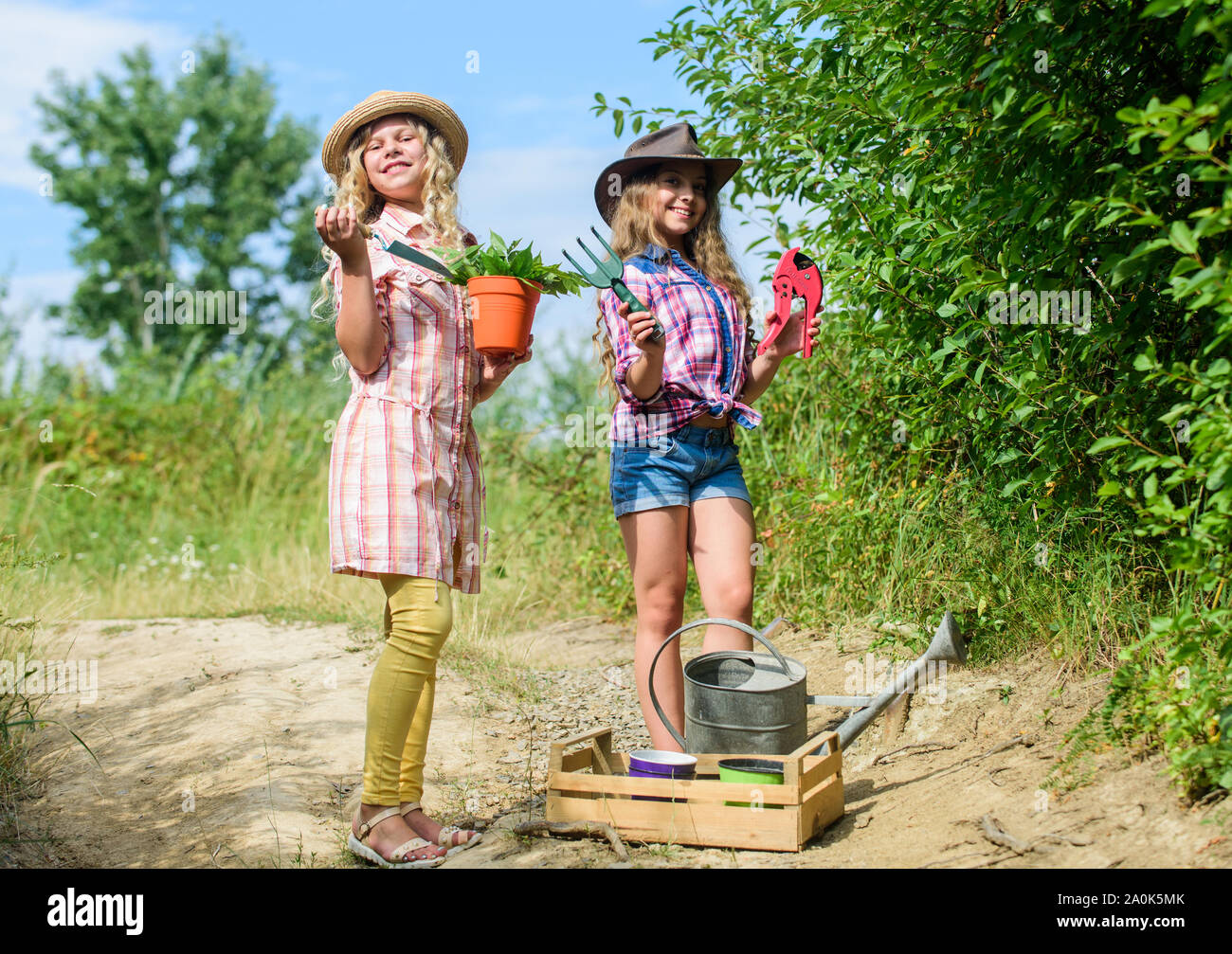 L'écologie et la protection de l'environnement. L'agriculture et  l'agriculture. printemps campagne. Les enfants occupent les outils de  jardinage. Le jour de la terre. L'été ferme familiale. les petites filles  agriculteur au village.