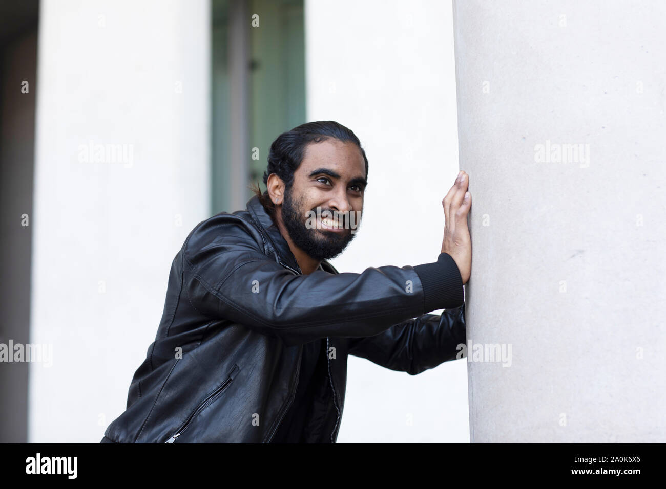 Jeune homme poussant un mur Banque D'Images