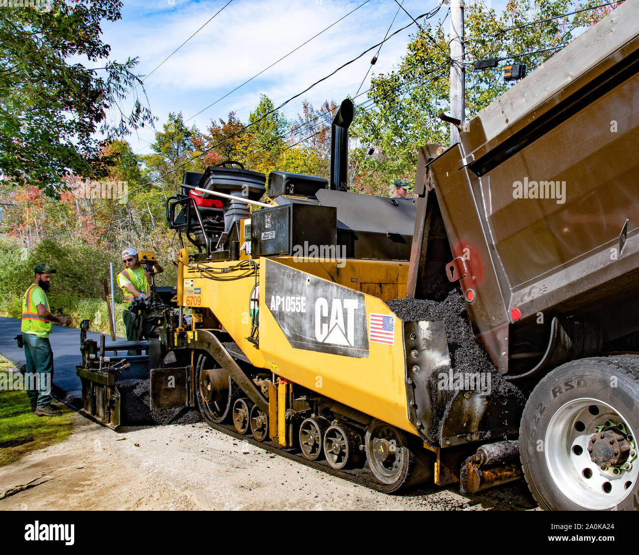 Un camion à benne et une machine de pavage asphalte neuf pose sur un village-rue de spéculateur, NY USA au début de l'automne Banque D'Images