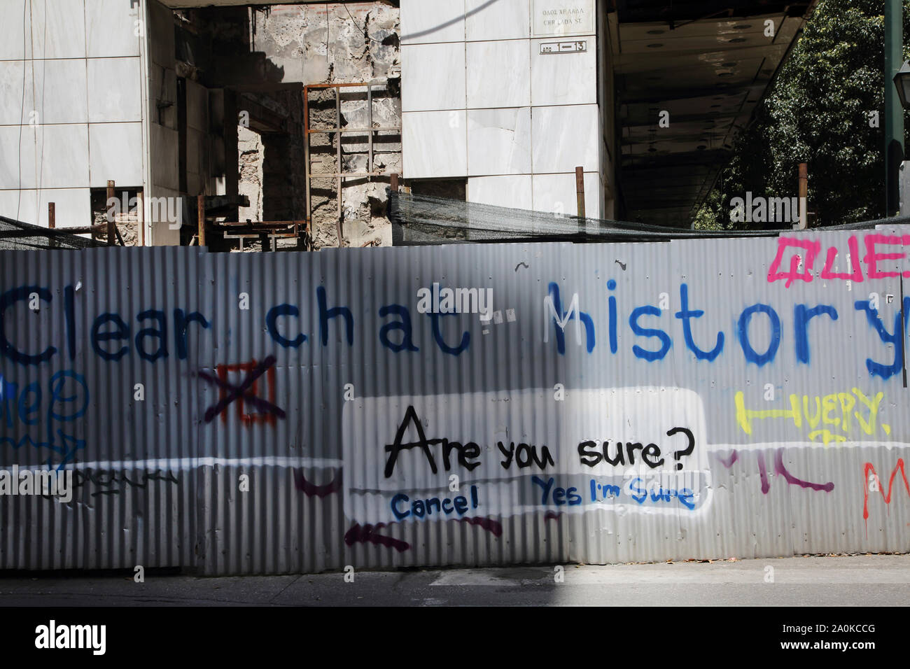 Grèce Athènes Graffiti sur une clôture autour de métal ondulé bâtiment abandonné sur Christou Lada Street Banque D'Images
