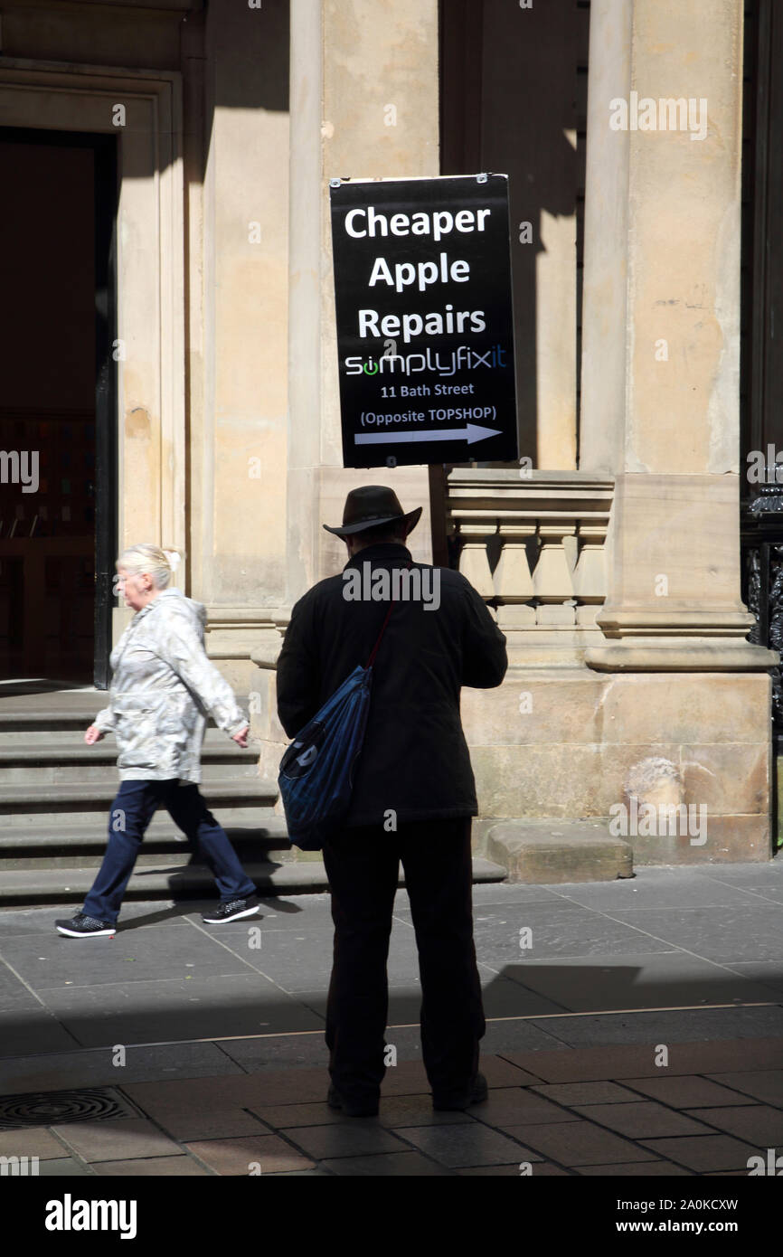 L'Écosse Glasgow Buchanan Street Man holding up Publicité pour les réparations Apple Banque D'Images