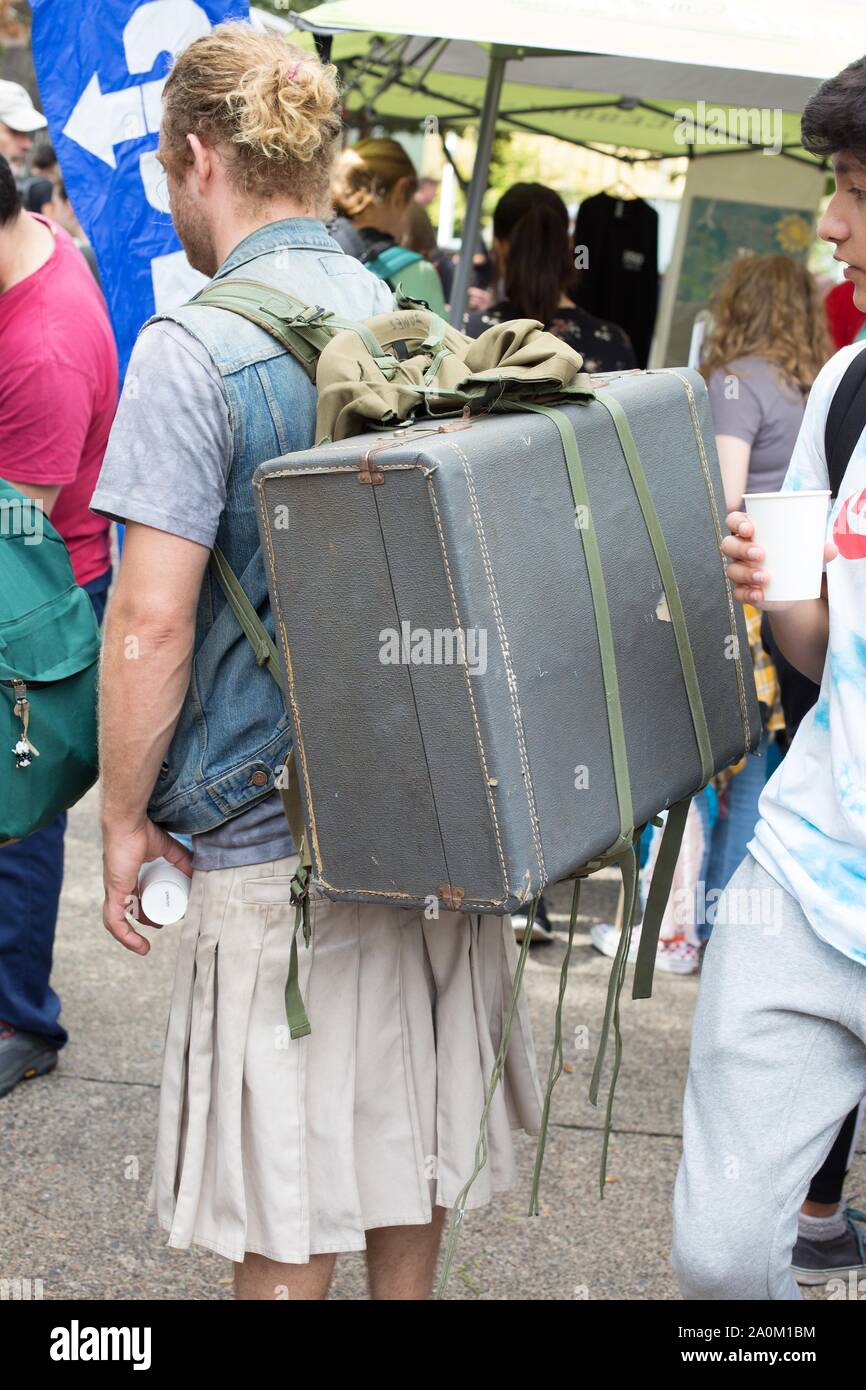 Un homme portant une jupe et une ancienne valise fixé à son retour, lors de la grève, rassemblement à Eugene, Oregon, USA. Banque D'Images