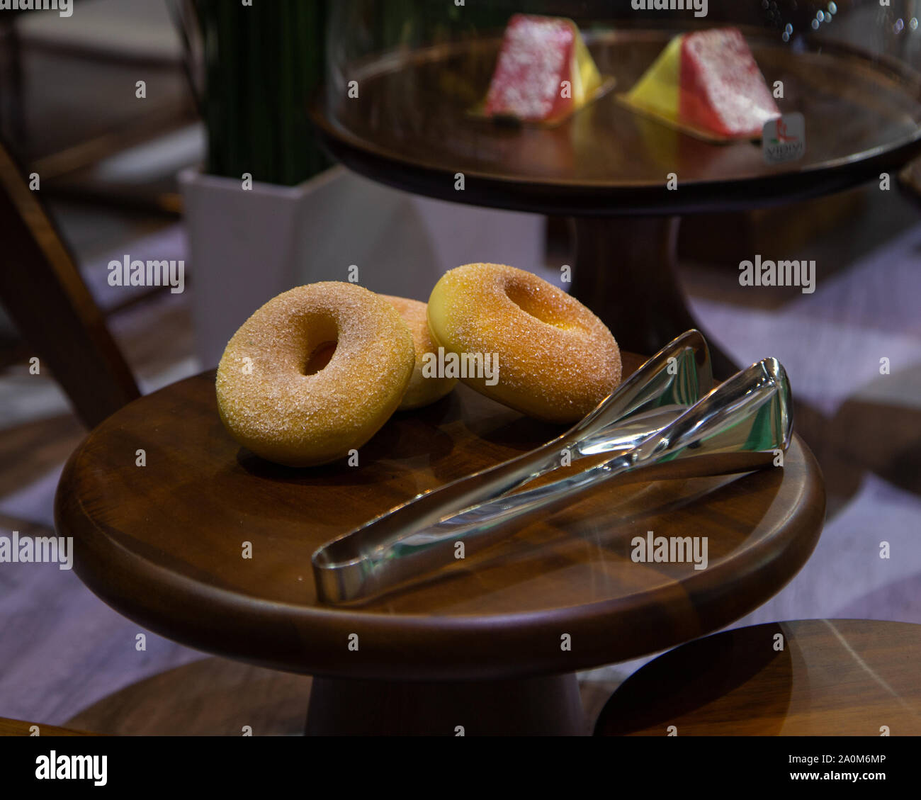 Trois donuts avec des pinces sur plateau en bois Banque D'Images