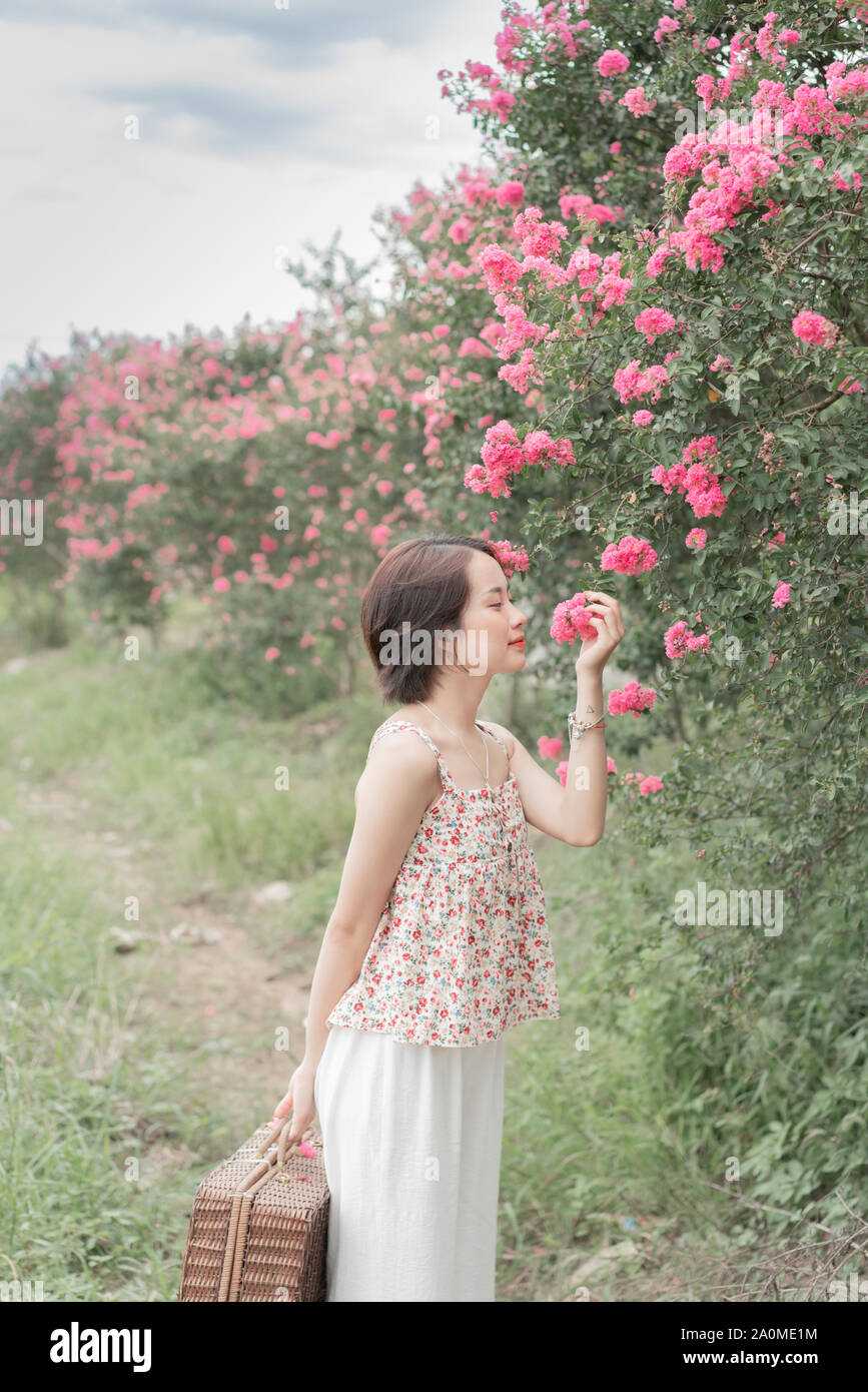 Belle fille par le confetti rose garden, fille portant un mignon et belle robe Banque D'Images