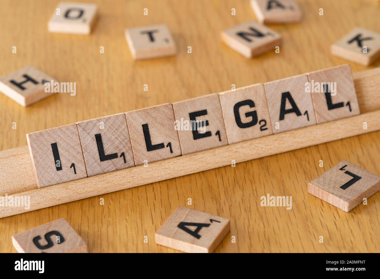 Lettres de scrabble en bois sur un rack l'orthographe du mot illégal Banque D'Images