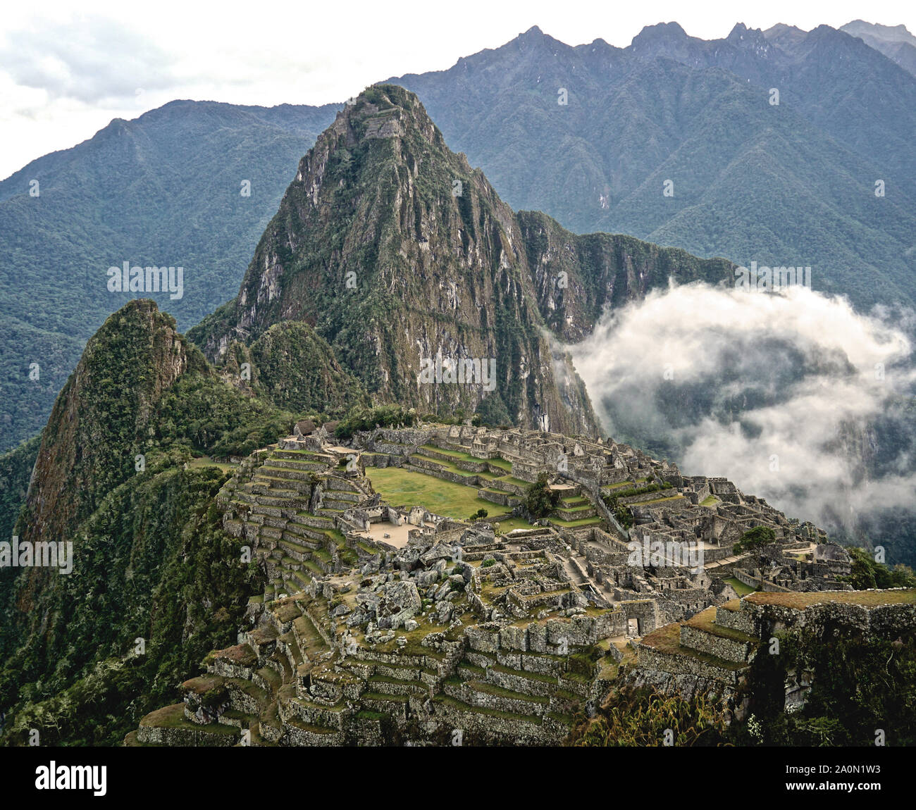 Le Machu Picchu est une citadelle Inca situé en altitude, dans la cordillère des Andes, au Pérou, au-dessus de la vallée de la rivière Urubamba. Construit au 15ème siècle et abandonné plus tard, c'est renommé pour ses murs de pierres sèches que le fusible de blocs énormes sans l'utilisation de mortier, bâtiments fascinants qui jouent sur des alignements astronomiques et vue panoramique. Son ancien usage exact reste un mystère. Il est 7 970 pieds (2 430 mètres) au-dessus du niveau de la mer sur le versant oriental des Andes Banque D'Images
