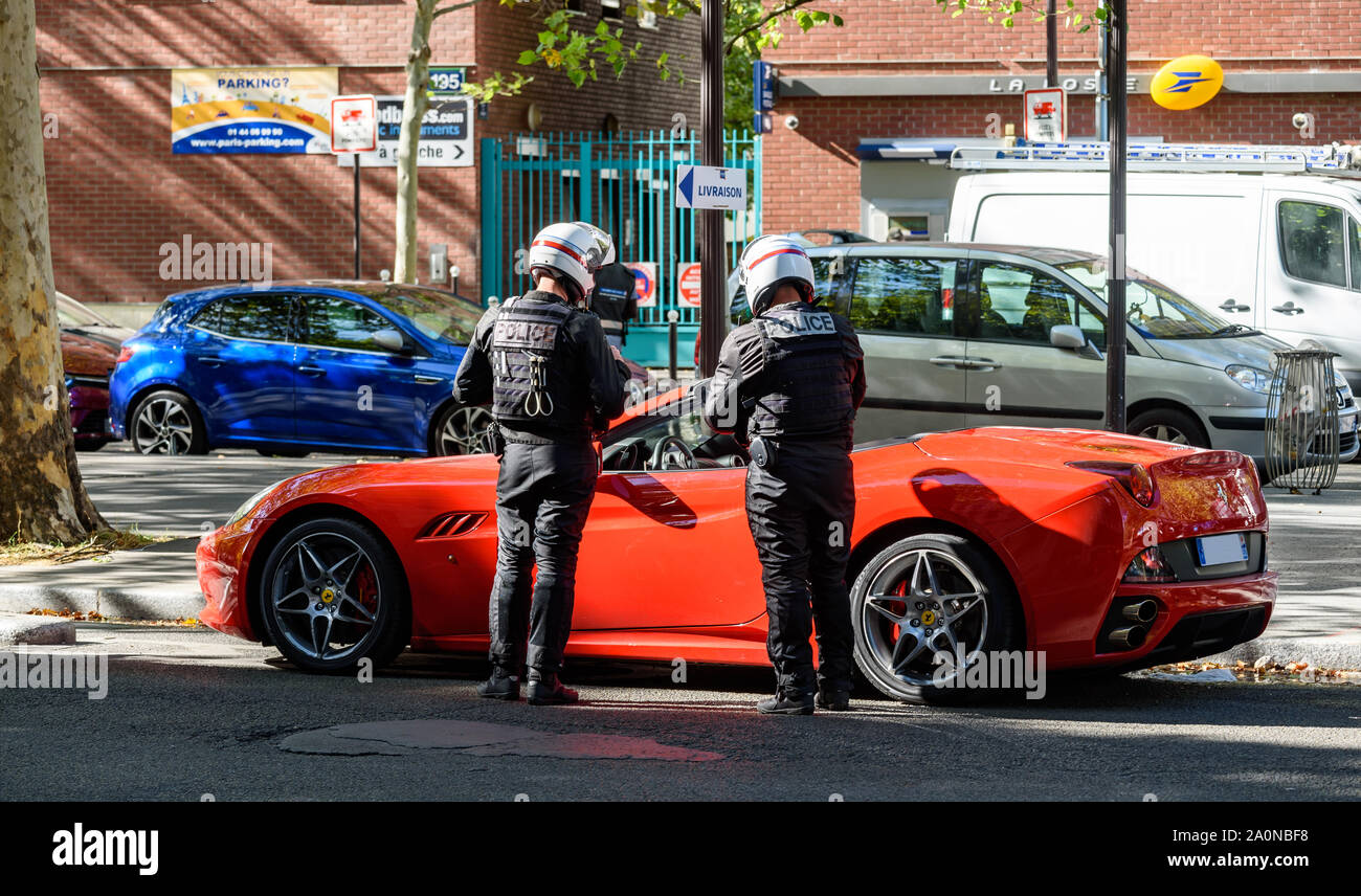 PARIS, FRANCE - 18 septembre 2019 : les agents de police de contrôler une moto de luxe voiture sport rouge dans une rue de Paris. Banque D'Images
