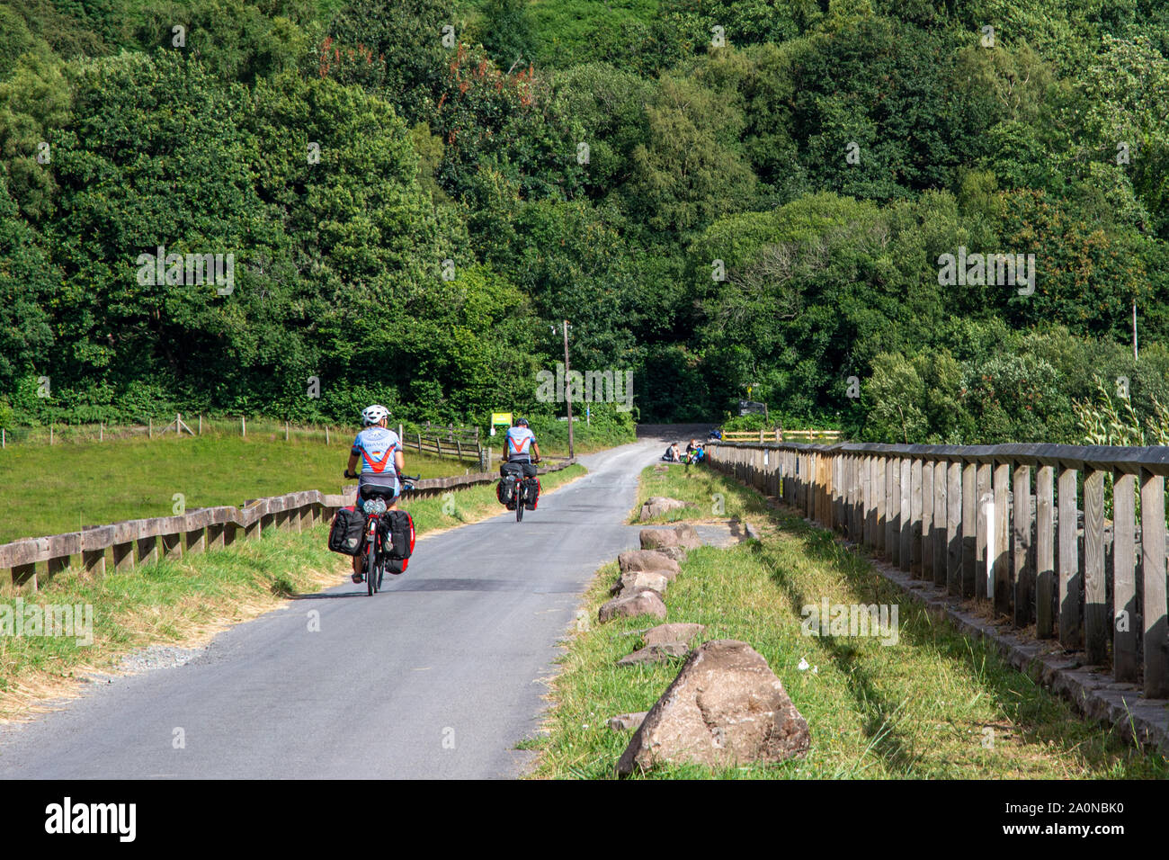 Merthyr Tydfil, Wales, UK - 18 juillet 2019 : une paire de des cyclotouristes ride passé Talybont réservoir sur le réseau national Cycle route 8 dans les Brecon Bea Banque D'Images