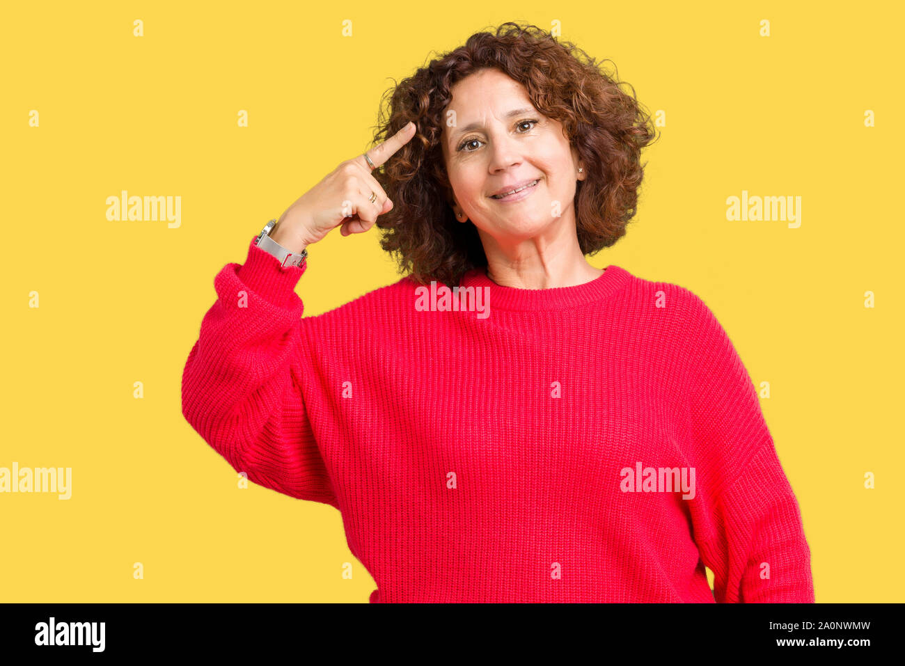 Beau milieu ager senior woman red winter sweater sur fond isolé Smiling pointant vers la tête avec un seul doigt, grande idée ou pensée, bonne m Banque D'Images