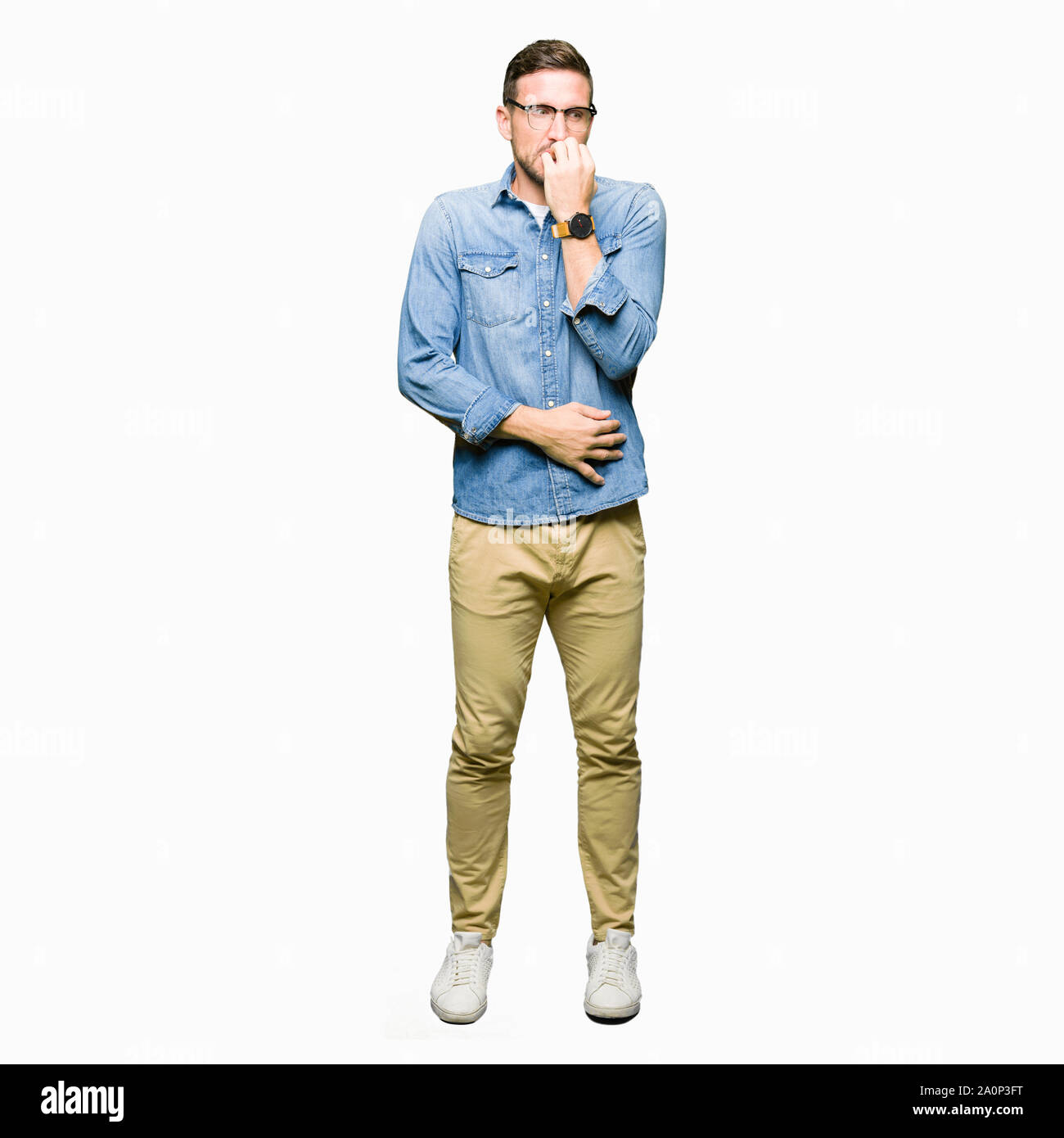 Bel homme portant des lunettes à souligné et nerveux avec les mains sur la bouche de mordre les ongles. Problème d'anxiété. Banque D'Images