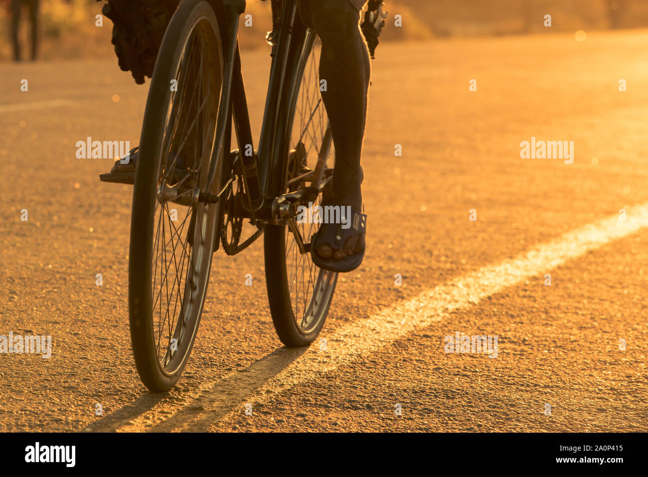 Libre de vélo roues/pneus sur une route goudronnée au Mozambique au lever du soleil. African/trajet cycliste du Mozambique au marché. La ville de Nampula, Mozambiqu Banque D'Images