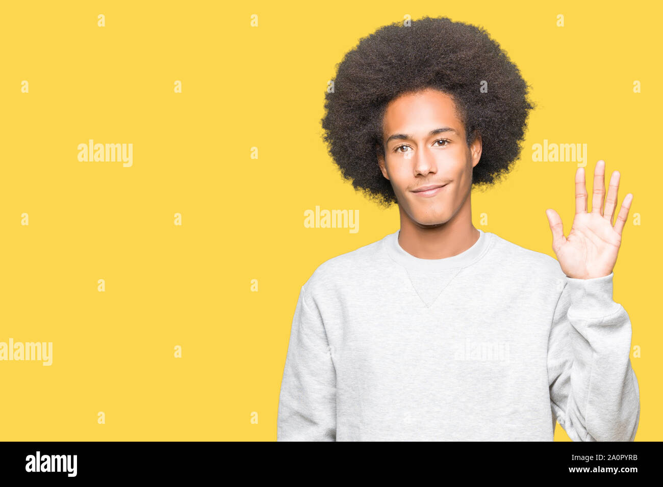 Young african american man with afro hair portant des sweat sportif renonce à dire bonjour heureux et souriant, aimable geste de bienvenue Banque D'Images