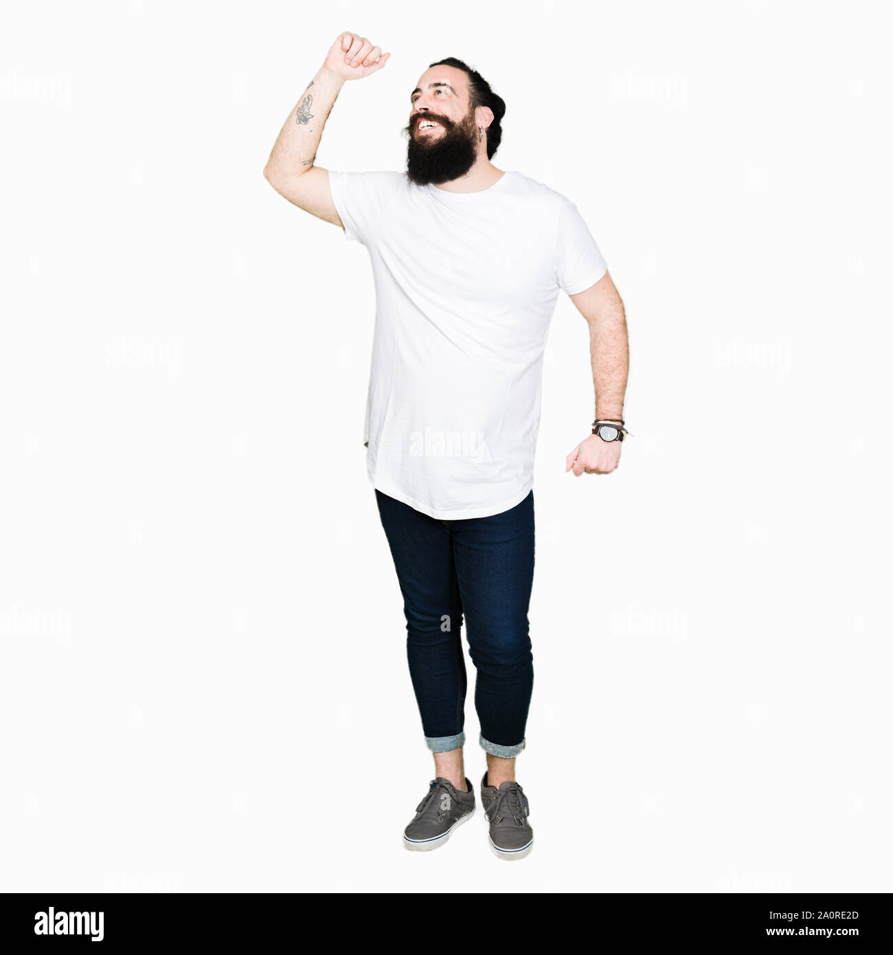 Jeune homme hipster avec de longs cheveux et la barbe blanche portant des T-shirt décontracté danse heureux et joyeux, souriant et décontracté en mouvement à l'écoute confiante m Banque D'Images