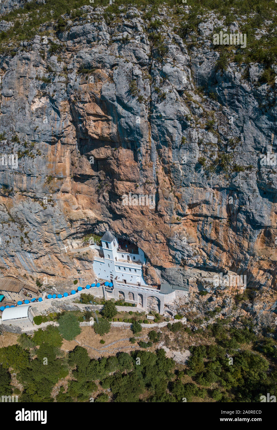 Vue aérienne du monastère d'Ostrog, Église orthodoxe serbe situé contre un fond de montagne vertical. Le Monténégro. Dédiée à saint Basile Banque D'Images