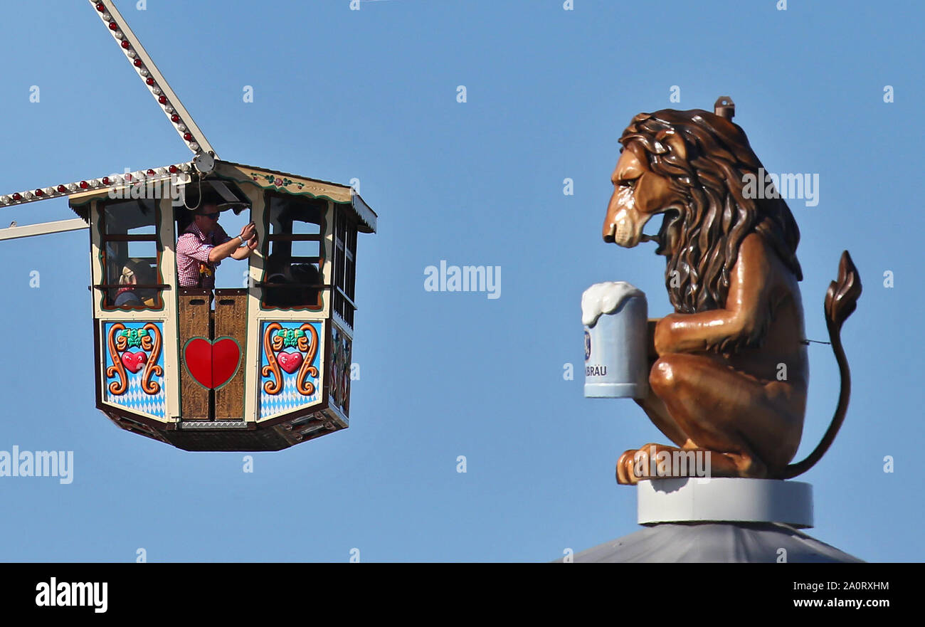 Munich, Allemagne. Sep 21, 2019. Début de l'Oktoberfest. Un homme prend une photo d'une nacelle de la grande roue à l'avant du lion de l'Löwenbräuzelt. Le plus grand festival de musique folklorique dans le monde dure jusqu'au 6 octobre. Credit : Karl-Josef Opim/dpa/Alamy Live News Banque D'Images