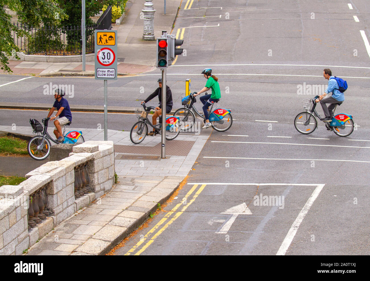 Quatre cyclistes roulent sur des vélos de location des vélos de location à cycle dédié lane Dublin, Irlande. Mode de vie à faible carbone écologique Banque D'Images