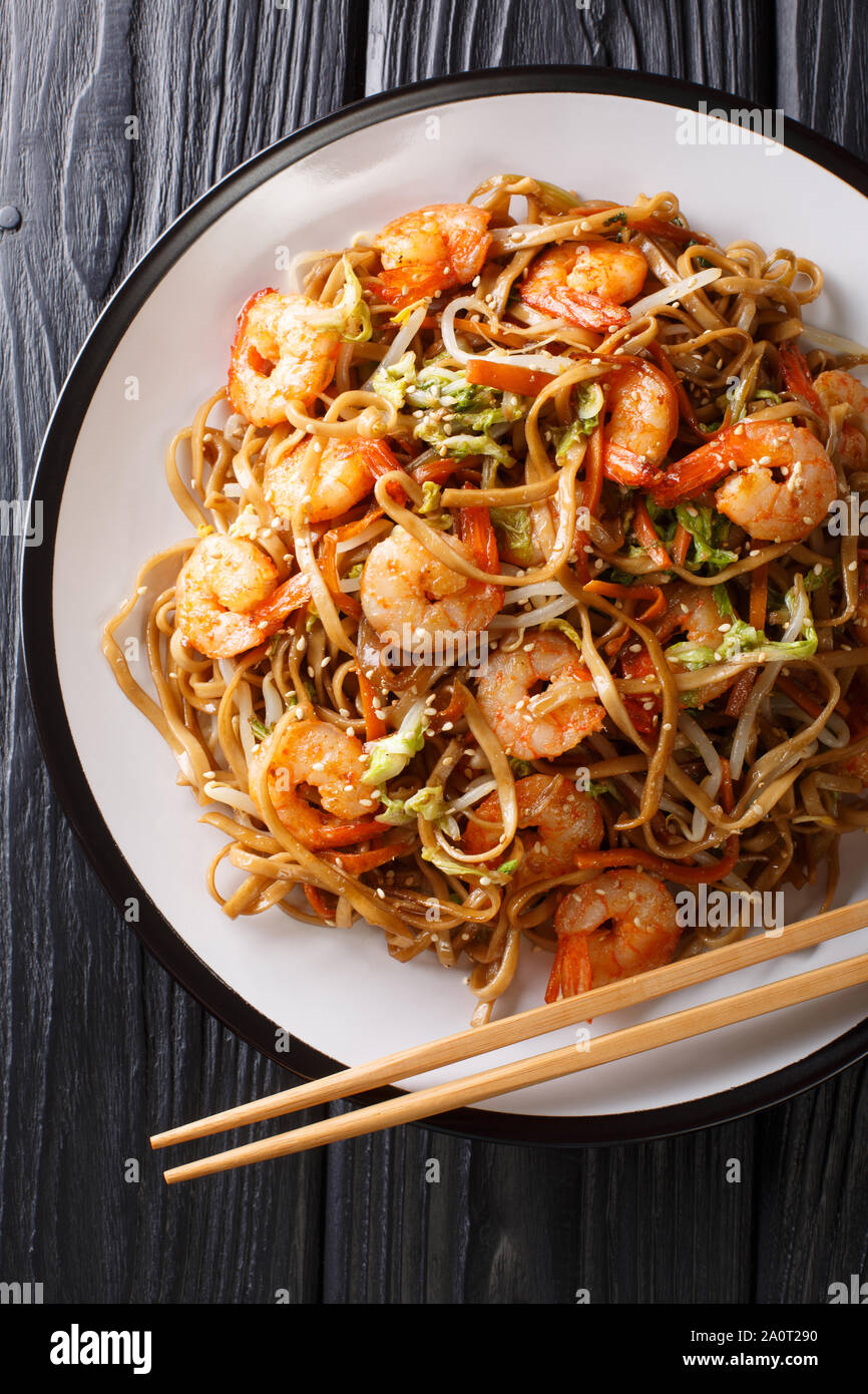 Portion de nouilles chow mein aux crevettes et légumes close-up sur une plaque sur la table. Haut Vertical Vue de dessus Banque D'Images