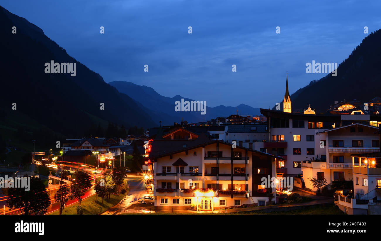 Soir le paysage urbain de Ischgl, une ville dans la vallée de Paznaun, Tyrol, Autriche. Voyant rouge allumé et sentiers bâtiments avec effet d'étoile. Banque D'Images