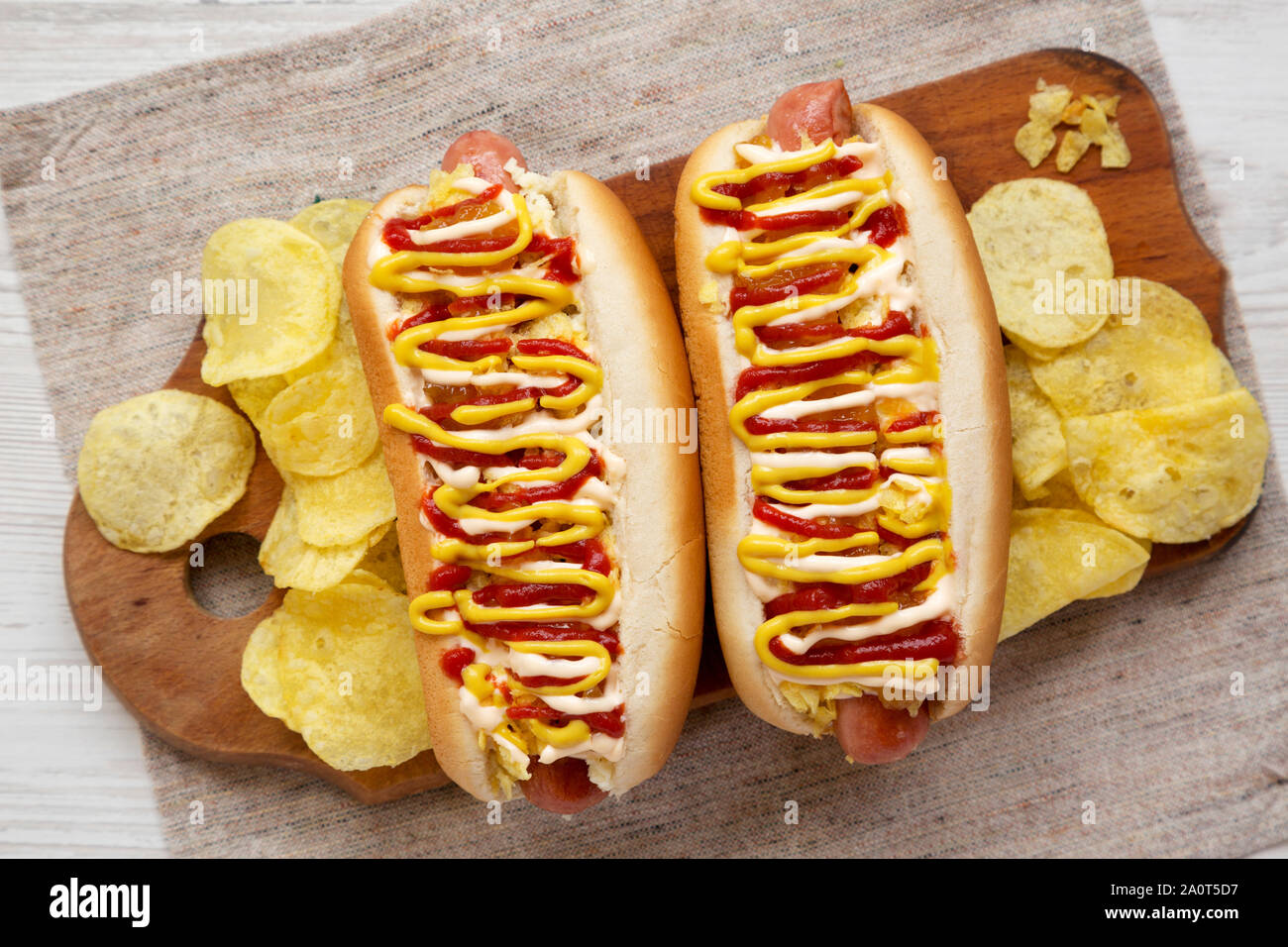 Des hot-dogs colombien avec l'ananas, sauce moutarde et ketchup mayo jaune sur une planche de bois rustique, vue de dessus. Mise à plat, vue du dessus, overh Banque D'Images