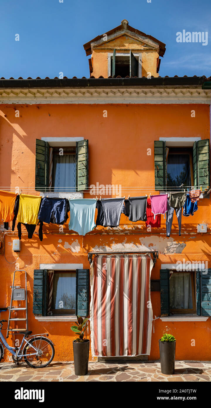 Lave-linge en train de sécher dehors aux fenêtres des maisons colorées sur l'île de Burano, Italie Banque D'Images