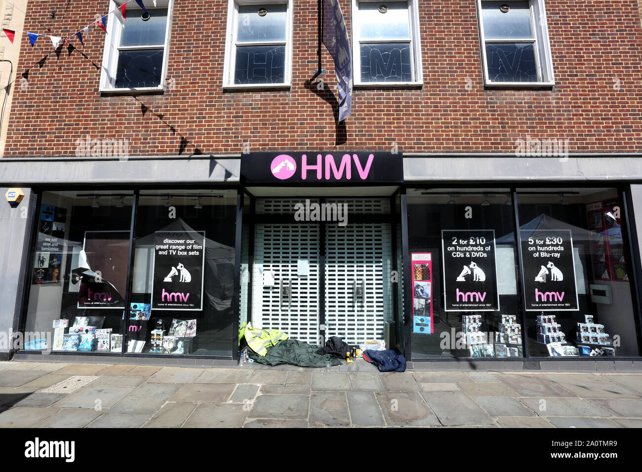 Vue générale d'un magasin HMV fermé avec des sans-abri dans l'embrasure de Chichester, West Sussex, UK. Banque D'Images