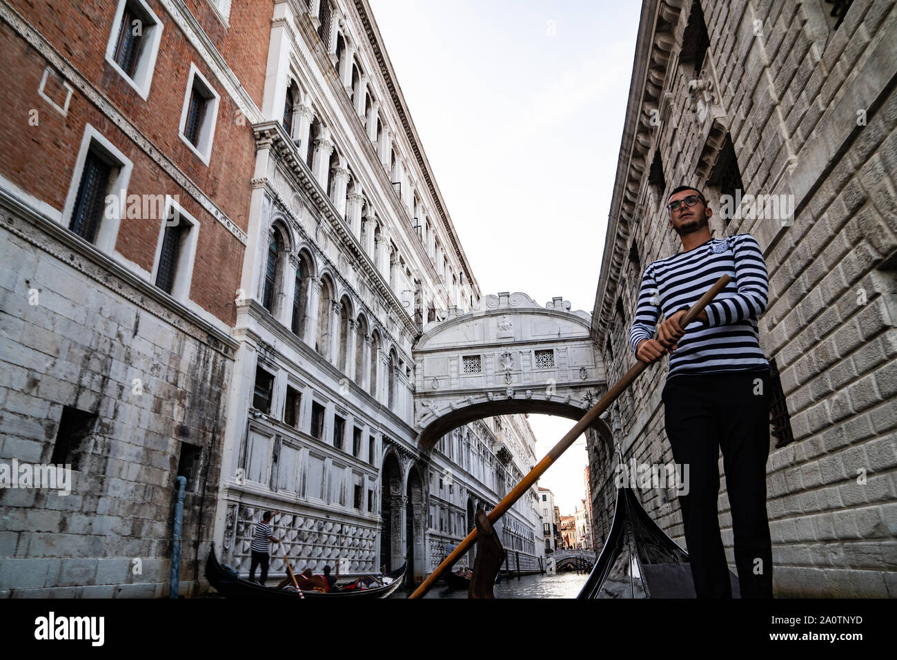 Gondolier sur une gondole sous le pont des soupirs (Ponte dei Sospiri), sur le rio di Palazzo, Venise, Italie Banque D'Images