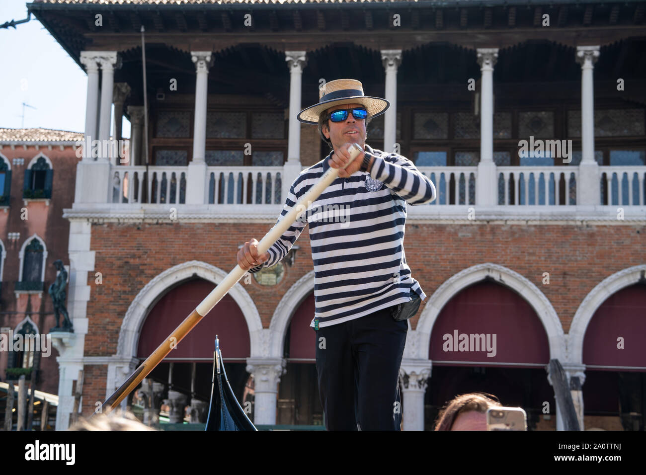 Un gondolier dans un chemise rayée et chapeau canotier de paille sur une  gondole sur les canaux de Venise, Italie. Porter des lunettes de soleil  miroir moderne Photo Stock - Alamy