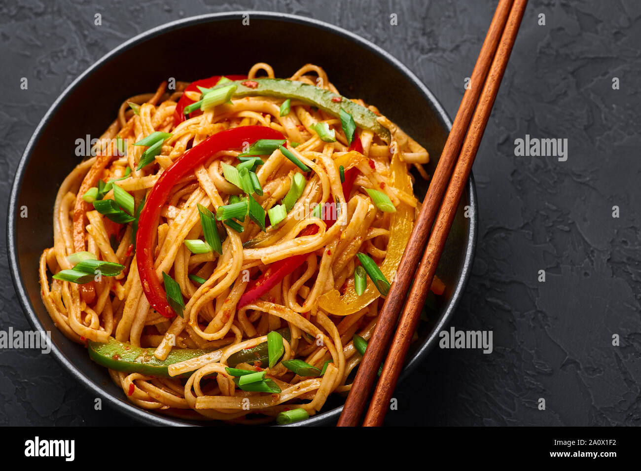 Nouilles Légumes végétarien Schezwan ou nouilles chow mein ou Hakka dans bol noir à fond sombre. Nouilles Schezwan est l'indo-chinoise sex dis Banque D'Images