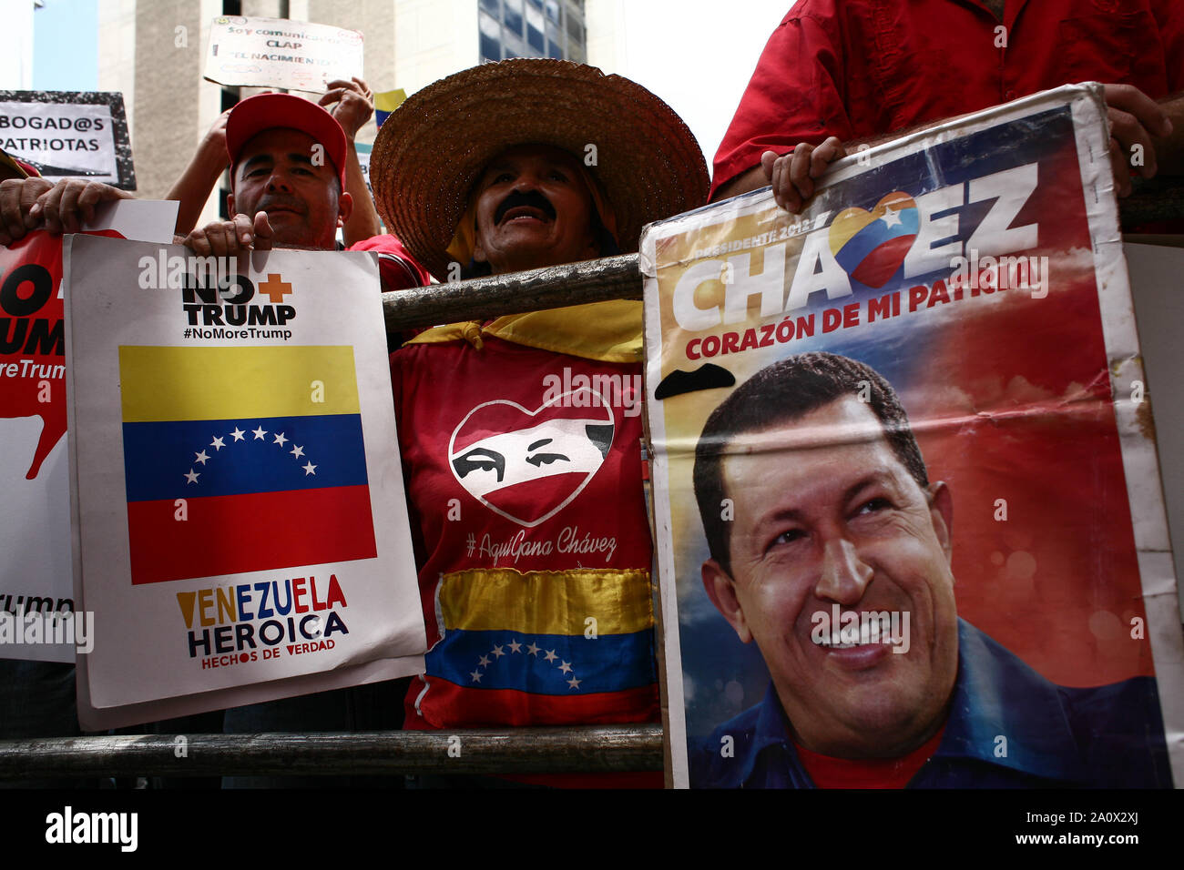 21 septembre 2019, le Venezuela, Caracas : Des manifestants sont maintenant des affiches, y compris le portrait de l'ancien président vénézuélien Chavez, au cours d'une manifestation dans les rues de la capitale du Venezuela contre les sanctions économiques imposées au pays par le président américain, Trump. Les manifestants veulent transmettre les boîtes avec plus de 13 millions de signatures de citoyens contre les sanctions des États-Unis et le Président Trump. Photo : Boris Vergara/dpa Banque D'Images