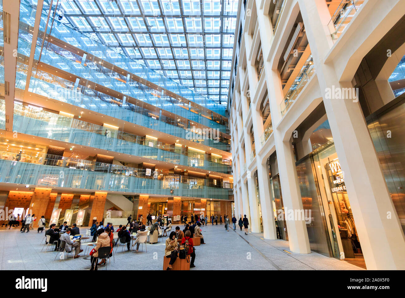 Tokyo, Marunouchi. JP tower KITTE l'intérieur du bâtiment. L'atrium triangulaire, étages de boutiques, toit et rez-de-chaussée coin avec des gens. La journée. Banque D'Images