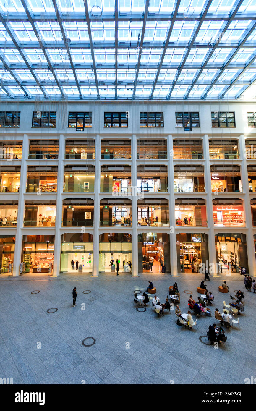 Tokyo, Marunouchi. JP tower KITTE l'intérieur du bâtiment. L'atrium triangulaire, boutiques, toit et rez-de-chaussée coin salon avec des gens assis. La journée. Banque D'Images