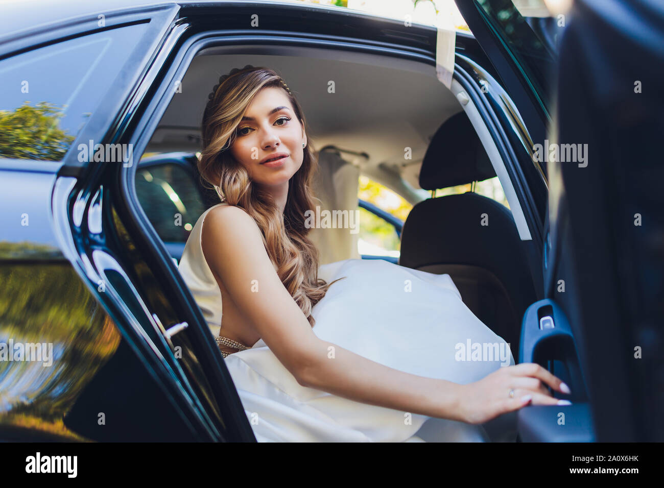 Une épouse qui prend des photos dans la voiture noire. Banque D'Images