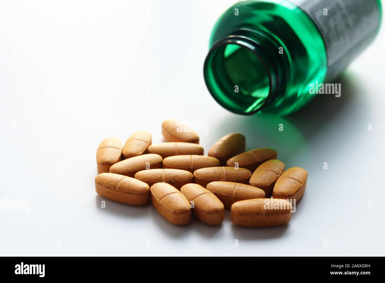 Les comprimés de multivitamines et vert bouteille récipient avec étiquette indiquant l'information nutritionnelle, le contenu et les apports quotidiens recommandés. Banque D'Images