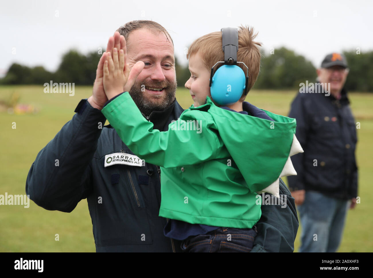 James Ketchell célèbre avec son neveu Max après son arrivée retour à l'aérodrome de Popham dans le Hampshire, après avoir été le premier à faire le tour du globe dans un gyrocopter. Les premiers à le féliciter sont ses parents John et Trish Ketchell. Banque D'Images