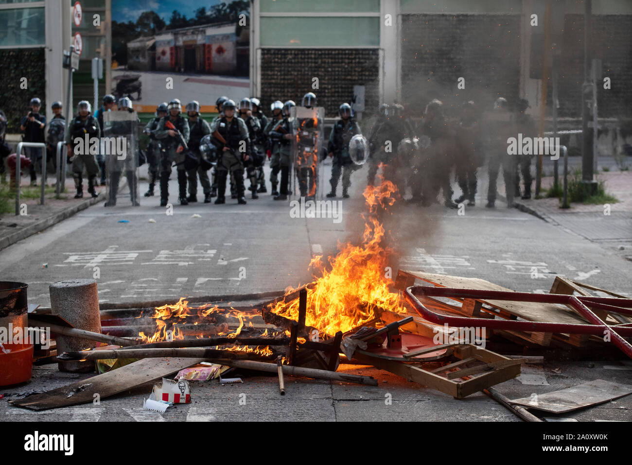 Des policiers à pied vers des barricades enflammées pendant la manifestation.encore une semaine, érigent des barricades en feu, brûlé un drapeau chinois et la police a tiré du gaz poivré dans de nouveaux affrontements au cours de griefs par les manifestants anti-gouvernementaux. Banque D'Images