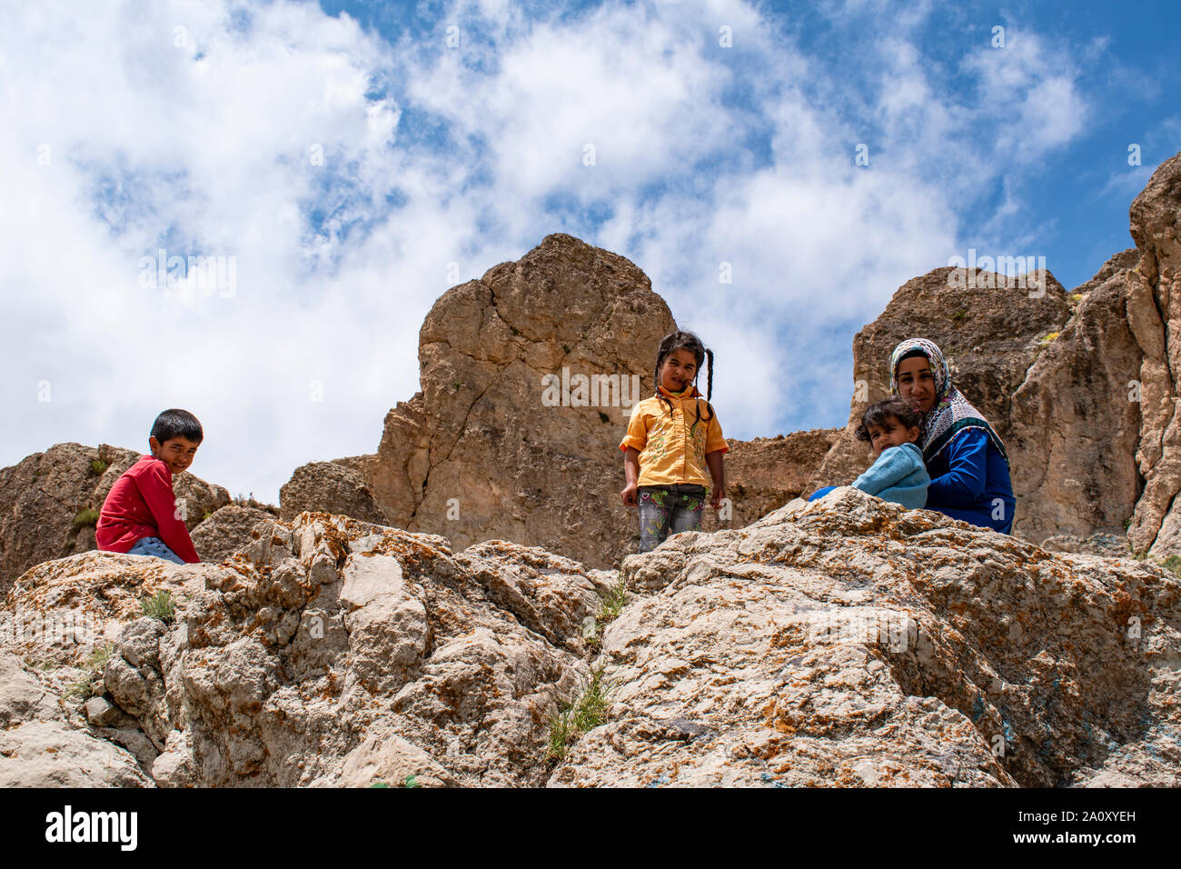Dogubayazıt : une femme kurde avec ses enfants sur les rochers jusqu'à la montagne à côté de l'ancien château de vieux Beyazit, près de l'Ishak Pasha Palace Banque D'Images