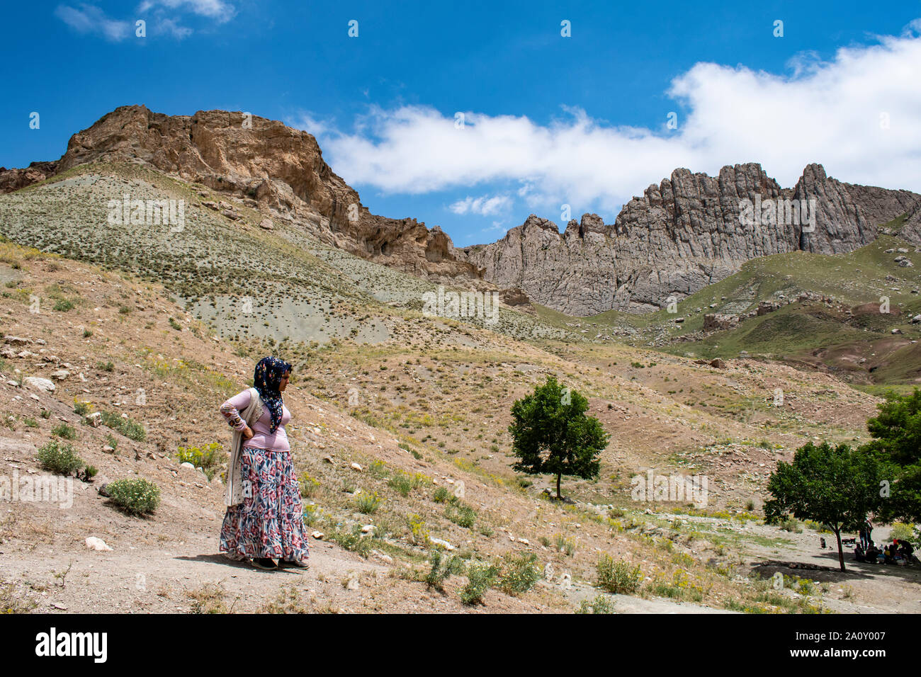 Dogubayazıt : femme kurde en vêtements traditionnels sur le trottoir près du château de vieux Beyazit, l'Ishak Pasha Palace et mosquée Eski Bayezid Cami Banque D'Images