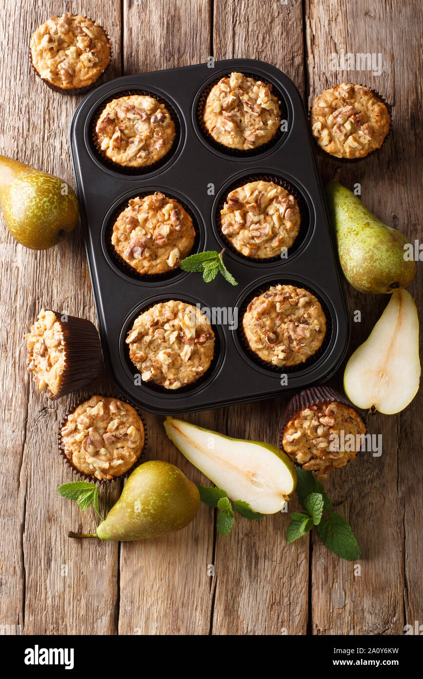 Muffins poire végétarien automne avec les noix dans un plat allant au four, gros plan sur la table. Haut Vertical Vue de dessus Banque D'Images