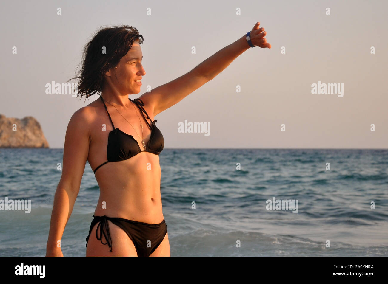 Belle jeune femme promenades le long de la surf au coucher du soleil sur la plage. détente vitalité concept de vie sain Banque D'Images