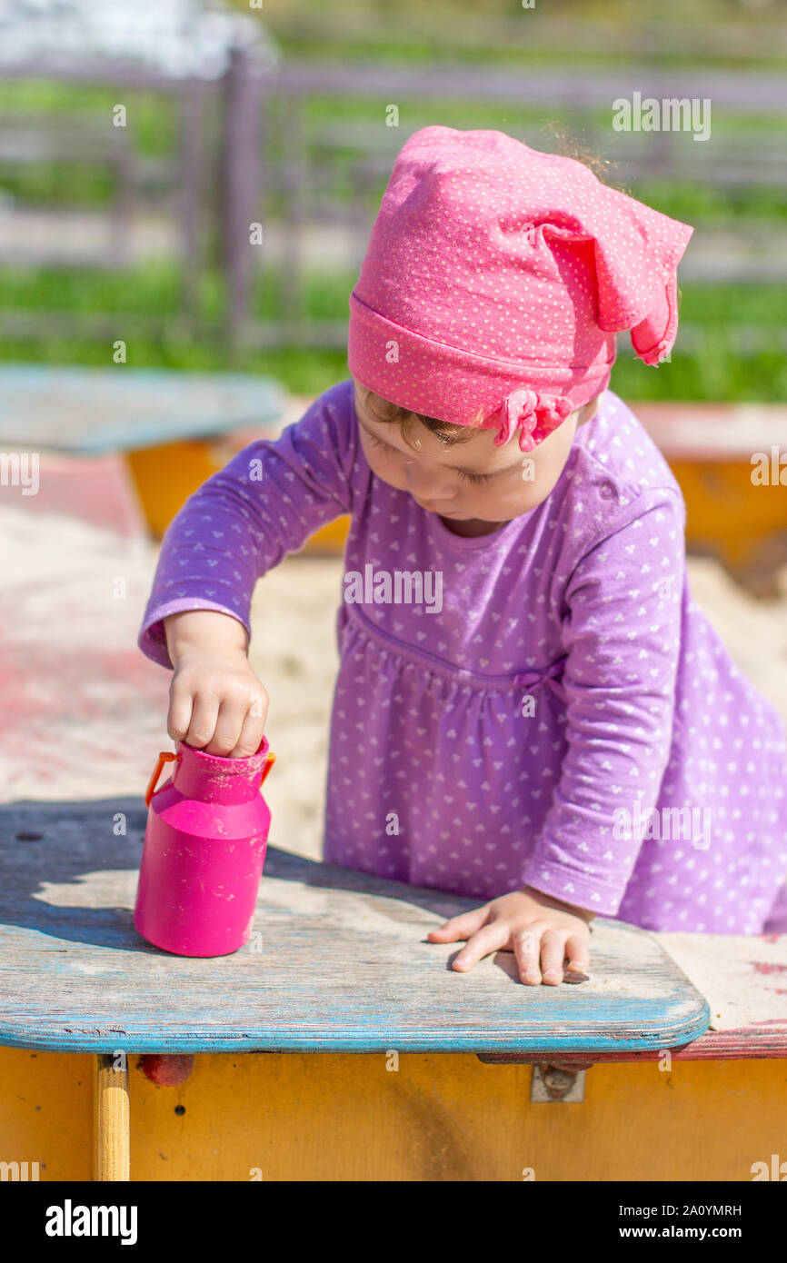 Bebe Fille 1 A Ans Dans Une Robe Pourpre Joue Avec Un Jouet De Plein Air Bidon En Plastique Heureux Caucasien Enfant Dans Un Chapeau Rose Sur Une Promenade Dans Le