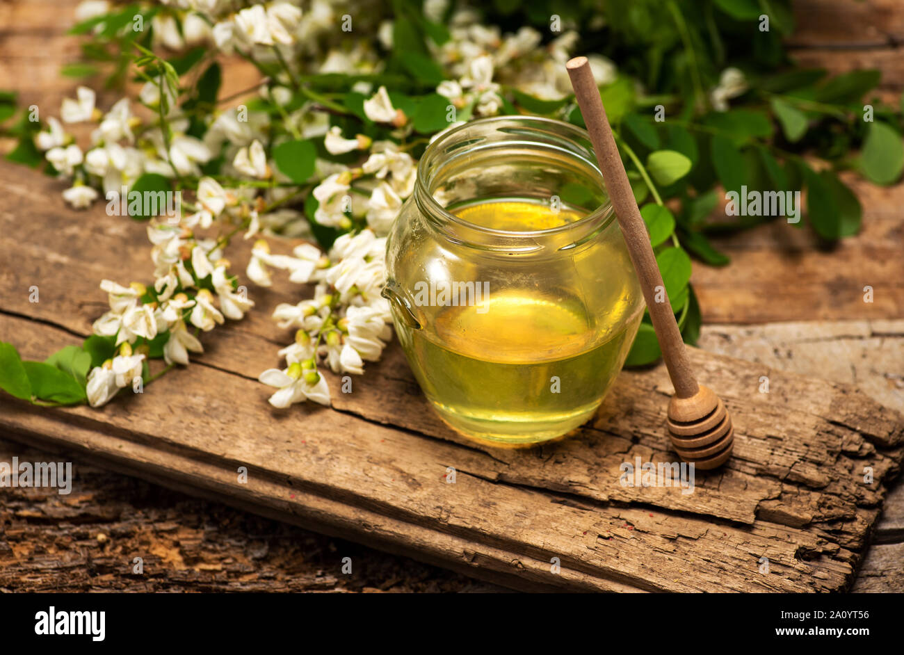Le miel dans un pot avec des fleurs d'acacia sur une table Banque D'Images